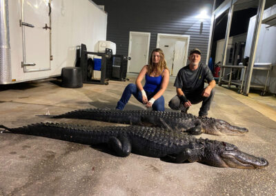 male and female posed with alligator