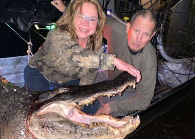 man and woman posing after alligator hunt